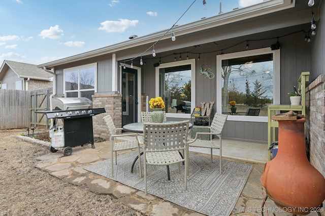 view of patio / terrace with outdoor dining area, fence, and a grill