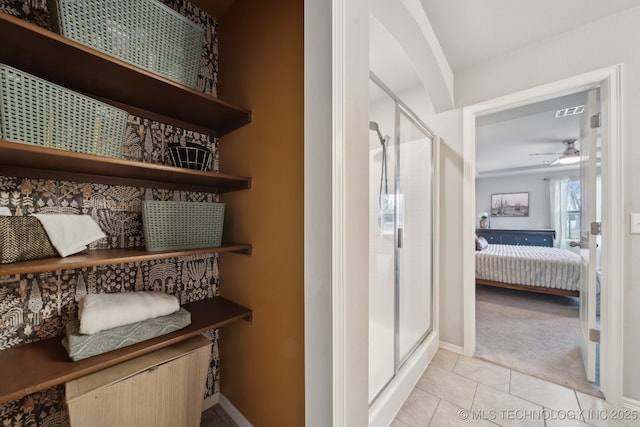 full bathroom featuring a ceiling fan, a stall shower, visible vents, and tile patterned floors