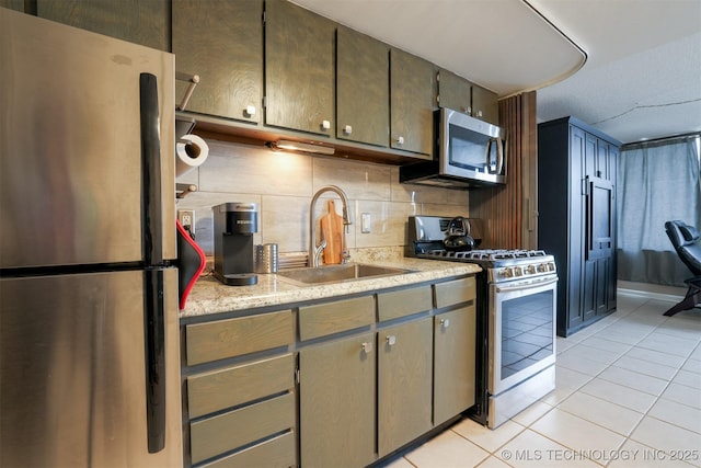 kitchen featuring appliances with stainless steel finishes, light tile patterned flooring, a sink, and tasteful backsplash