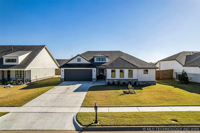 modern farmhouse featuring an attached garage, fence, driveway, a front lawn, and board and batten siding