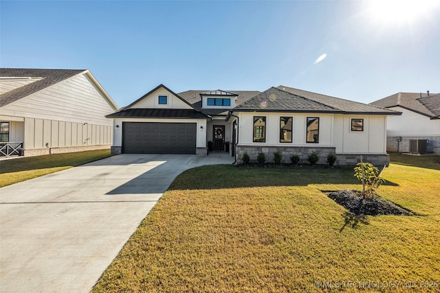 view of front of property featuring concrete driveway, a front yard, a standing seam roof, metal roof, and a garage