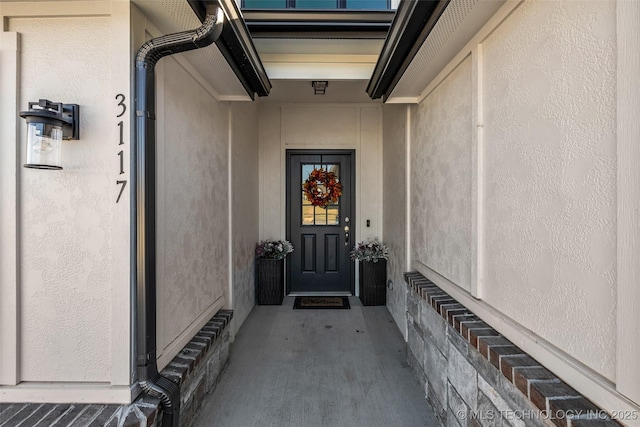 entrance to property featuring stucco siding