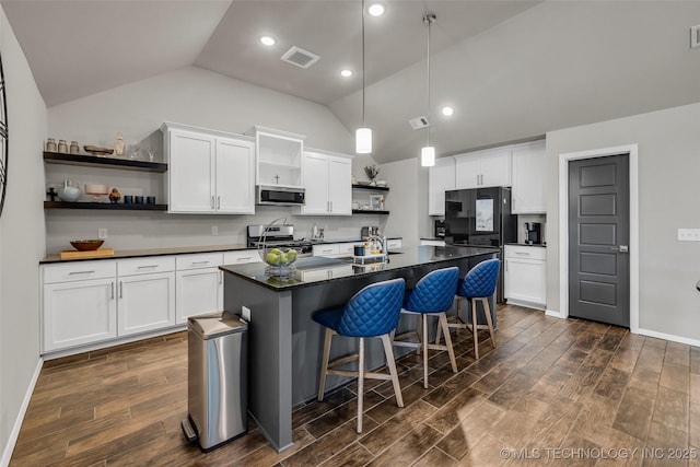 kitchen featuring open shelves, appliances with stainless steel finishes, dark countertops, and visible vents