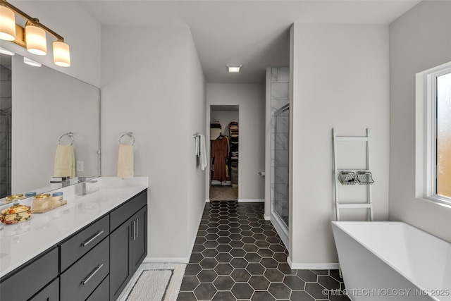 full bath featuring tile patterned flooring, a spacious closet, vanity, a freestanding tub, and a shower stall