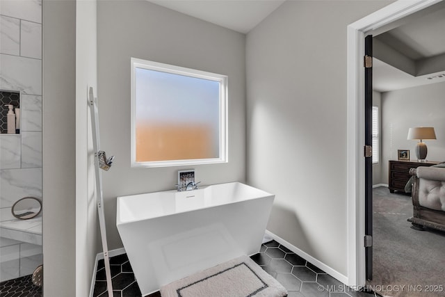 full bath featuring a sink, a soaking tub, baseboards, and tiled shower