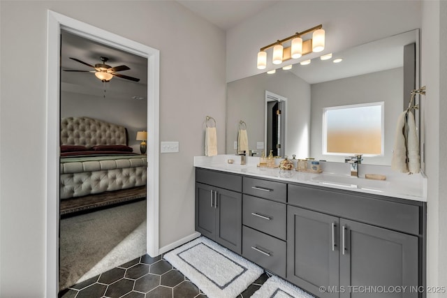 ensuite bathroom featuring ensuite bathroom, a sink, baseboards, tile patterned floors, and double vanity