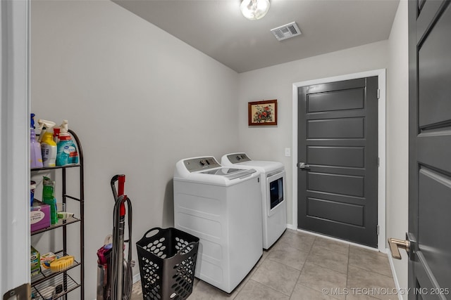 laundry room featuring visible vents, light tile patterned flooring, washer and dryer, laundry area, and baseboards