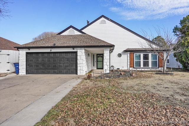 view of front of home with driveway, a shingled roof, and an attached garage