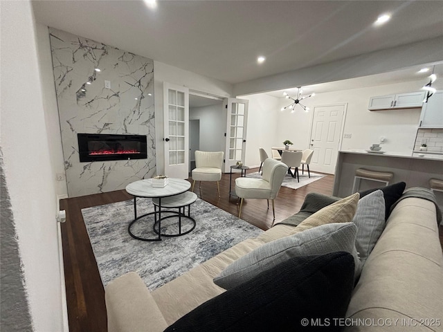 living room with recessed lighting, french doors, wood finished floors, and a high end fireplace