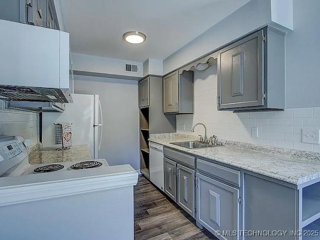 kitchen with visible vents, decorative backsplash, white dishwasher, gray cabinets, and a sink