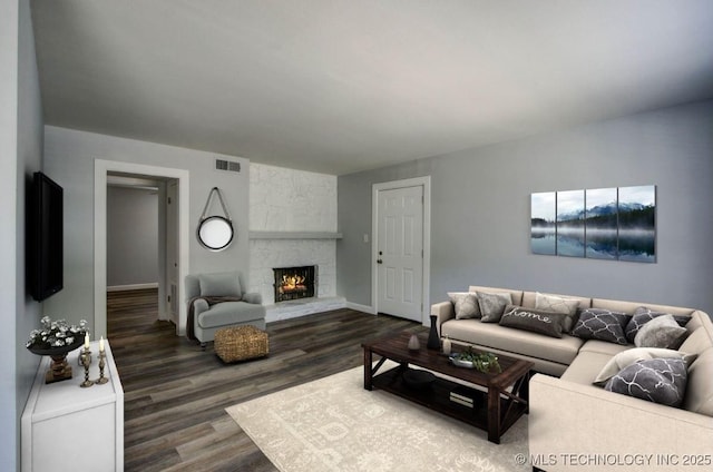 living area with dark wood-style floors, visible vents, a fireplace, and baseboards