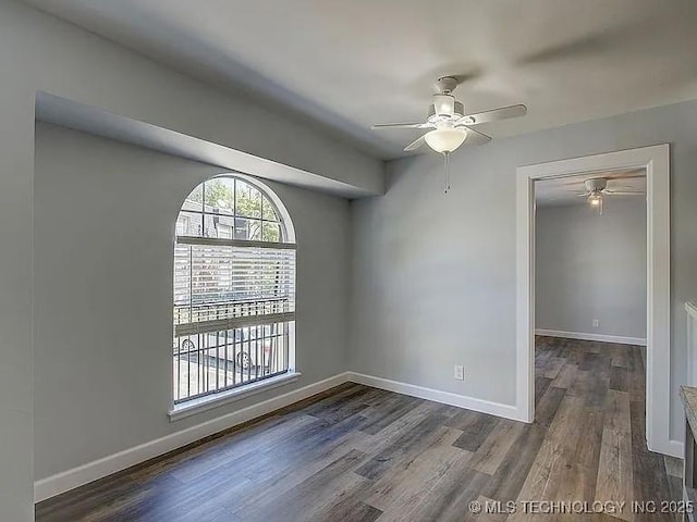 empty room featuring a ceiling fan, baseboards, and wood finished floors