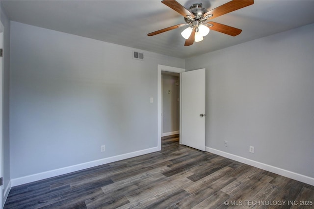 empty room with a ceiling fan, baseboards, visible vents, and dark wood-type flooring