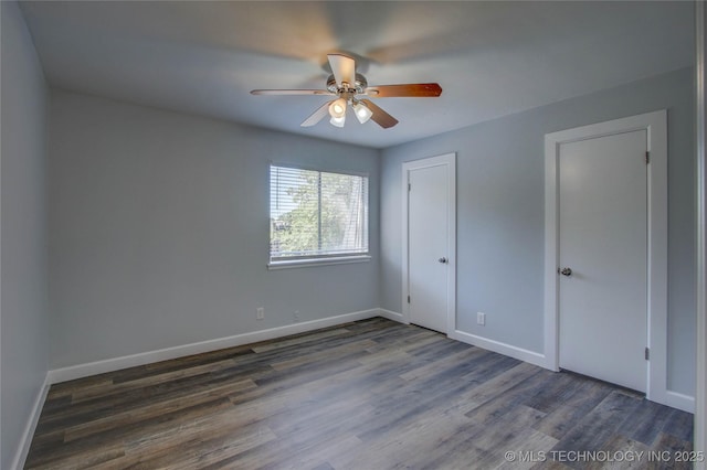 unfurnished bedroom with dark wood-style floors, baseboards, and a ceiling fan