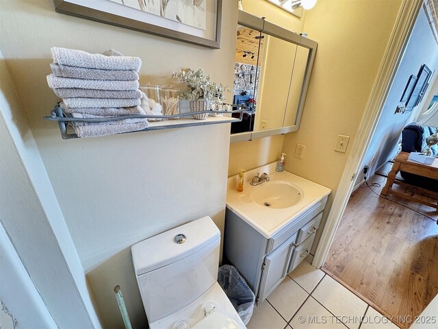 bathroom with toilet, tile patterned floors, and vanity