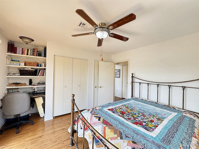 bedroom with light wood-style flooring, visible vents, and ceiling fan