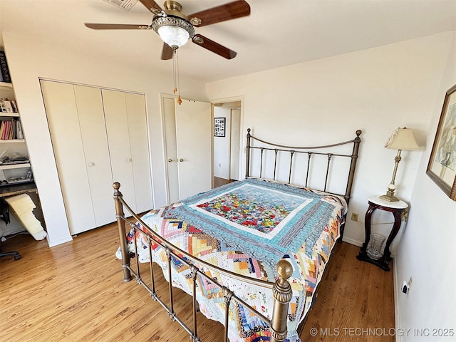 bedroom with a ceiling fan, a closet, visible vents, and wood finished floors