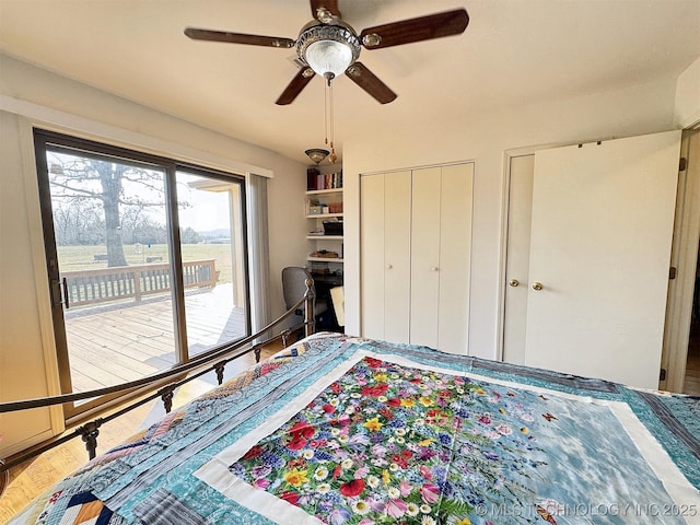 bedroom featuring ceiling fan, wood finished floors, two closets, and access to exterior