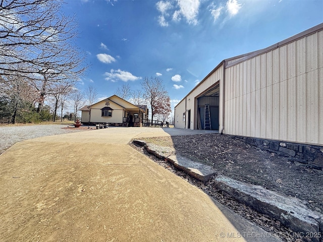 view of side of property featuring a garage, an outbuilding, and driveway