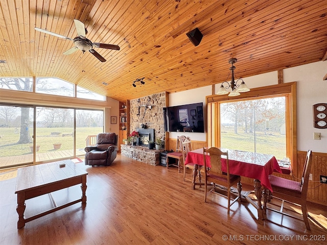 living room featuring lofted ceiling, wainscoting, wood finished floors, wooden ceiling, and ceiling fan with notable chandelier