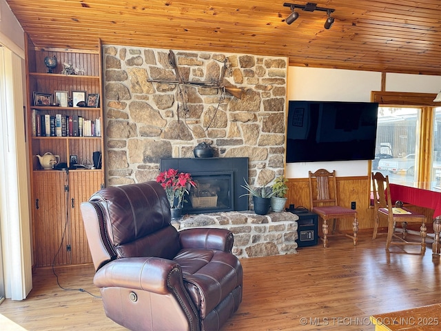 living area featuring wood ceiling, a fireplace, track lighting, and wood finished floors