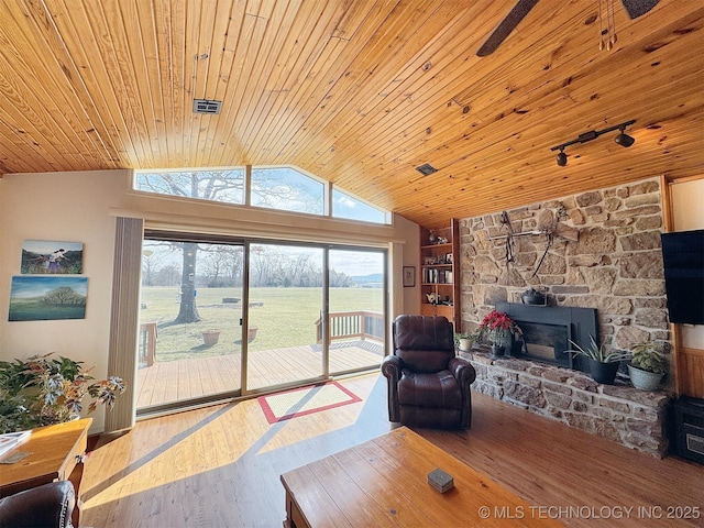 living room with lofted ceiling, a fireplace, wood finished floors, and wood ceiling