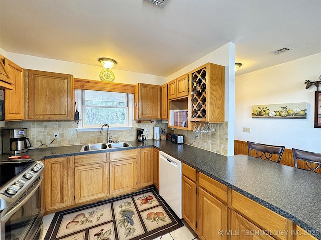 kitchen featuring tasteful backsplash, electric stove, dishwasher, dark countertops, and a sink