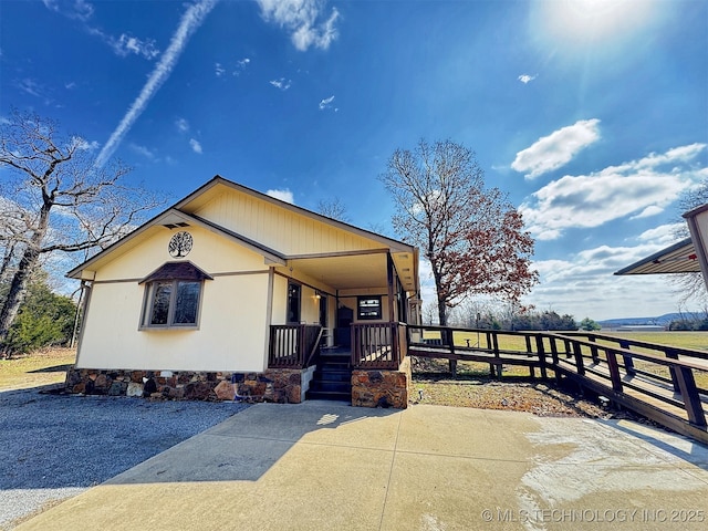 view of front facade featuring crawl space, covered porch, and fence