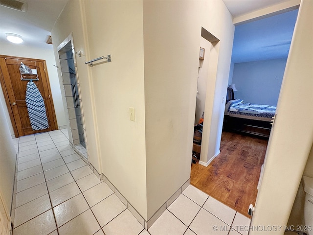 hallway featuring visible vents and light tile patterned floors