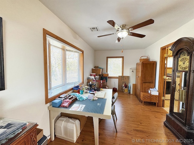 dining room featuring light wood finished floors, ceiling fan, and visible vents