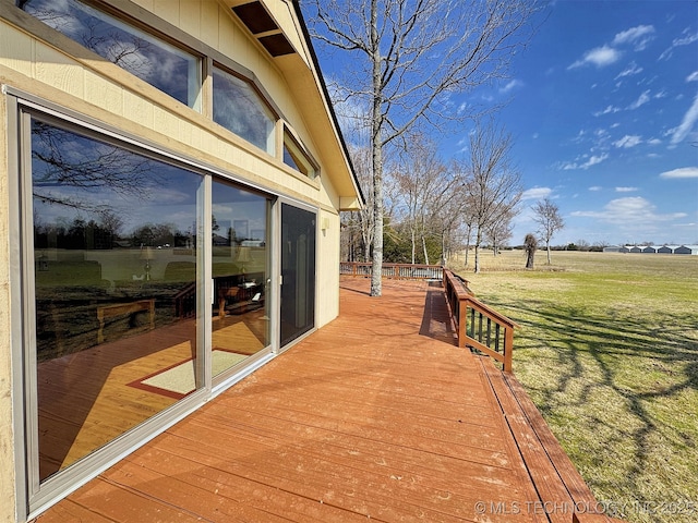 deck with a rural view and a yard