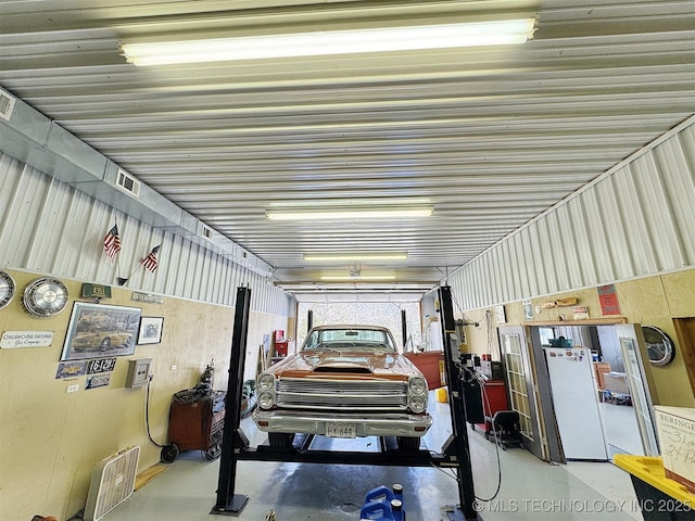 garage featuring freestanding refrigerator and metal wall