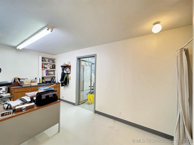 home office with finished concrete floors and baseboards