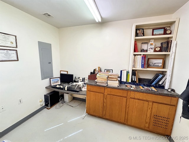 office featuring finished concrete flooring, electric panel, and visible vents