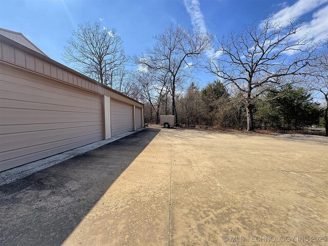 view of yard featuring an outbuilding and community garages