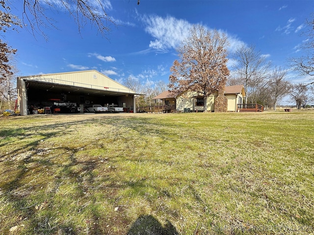 view of yard featuring a pole building, a carport, and an outdoor structure