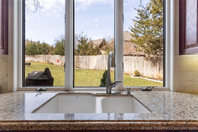 room details featuring light stone countertops and a sink