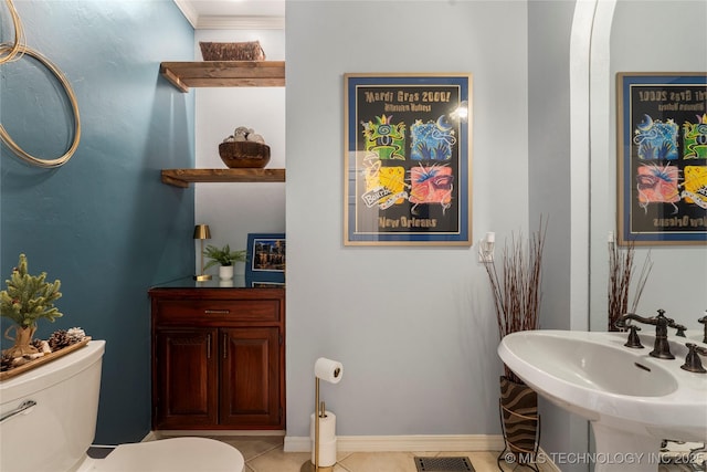 bathroom featuring visible vents, baseboards, toilet, tile patterned flooring, and a sink