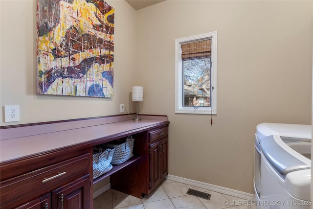 laundry room with light tile patterned floors, cabinet space, visible vents, washing machine and dryer, and baseboards