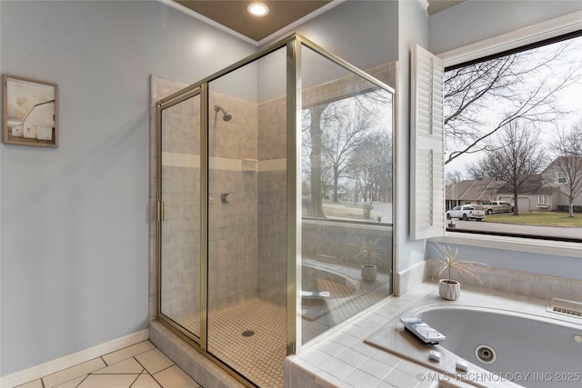 full bathroom featuring a stall shower, a jetted tub, baseboards, and tile patterned floors