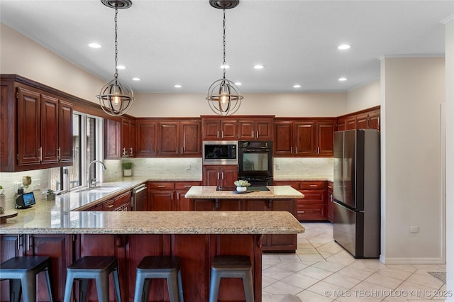 kitchen featuring a breakfast bar area, a peninsula, a sink, appliances with stainless steel finishes, and backsplash