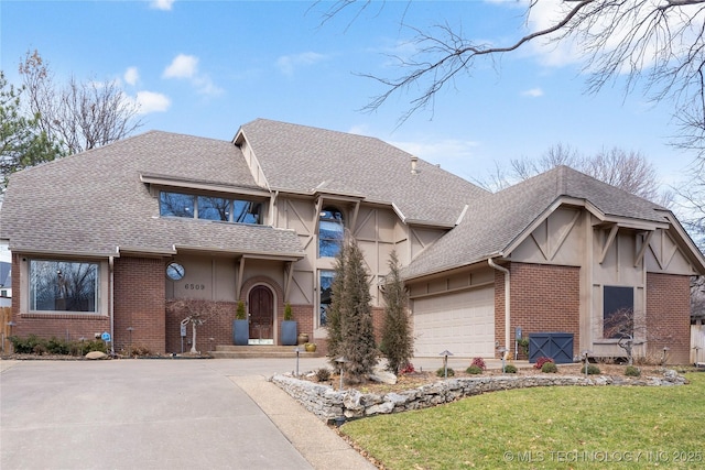 view of front facade with brick siding, a front lawn, and a shingled roof