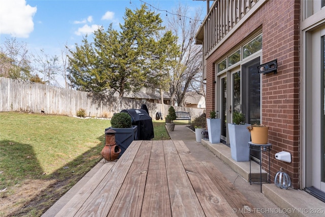 wooden deck featuring a yard, area for grilling, and a fenced backyard