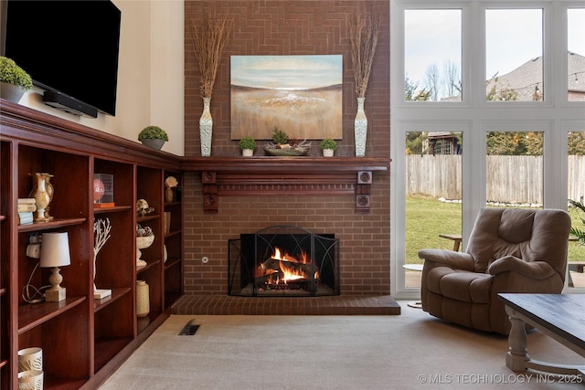 living area featuring carpet floors and a brick fireplace