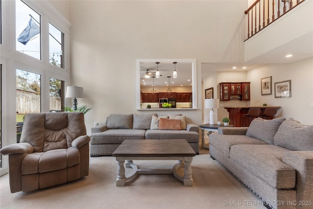 living room with a high ceiling and light colored carpet