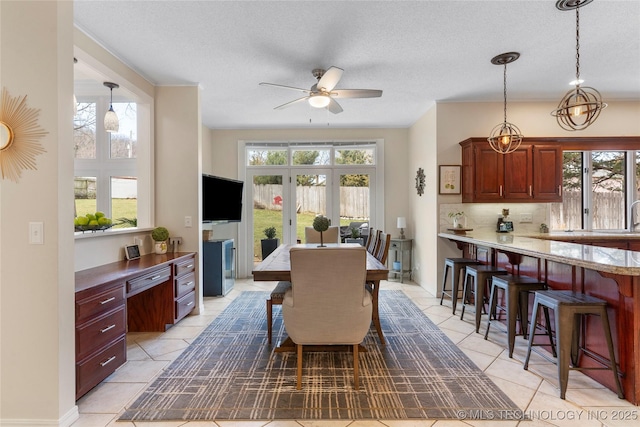 dining room with ceiling fan, a textured ceiling, and a wealth of natural light