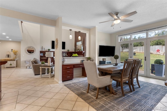 dining space featuring french doors, a ceiling fan, light tile patterned flooring, built in study area, and a textured ceiling