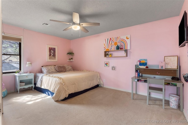 carpeted bedroom featuring baseboards, visible vents, ceiling fan, and a textured ceiling