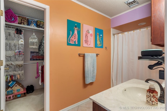 bathroom with a textured ceiling, baseboards, vanity, and crown molding