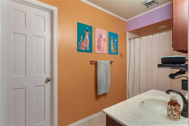 bathroom with baseboards, ornamental molding, tile patterned flooring, a textured ceiling, and vanity